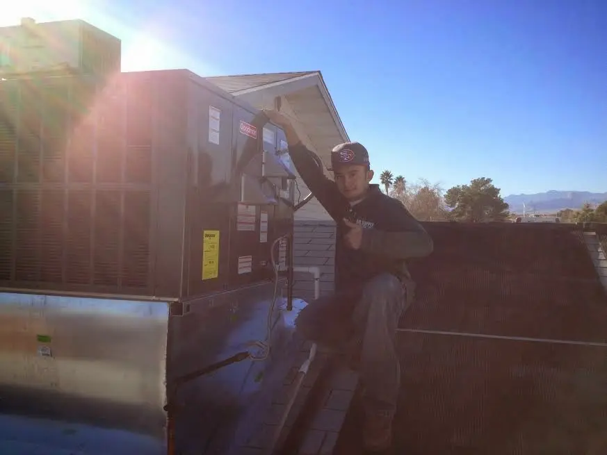 HVAC technician performing Heat Pump Repair on a rooftop unit in Morristown